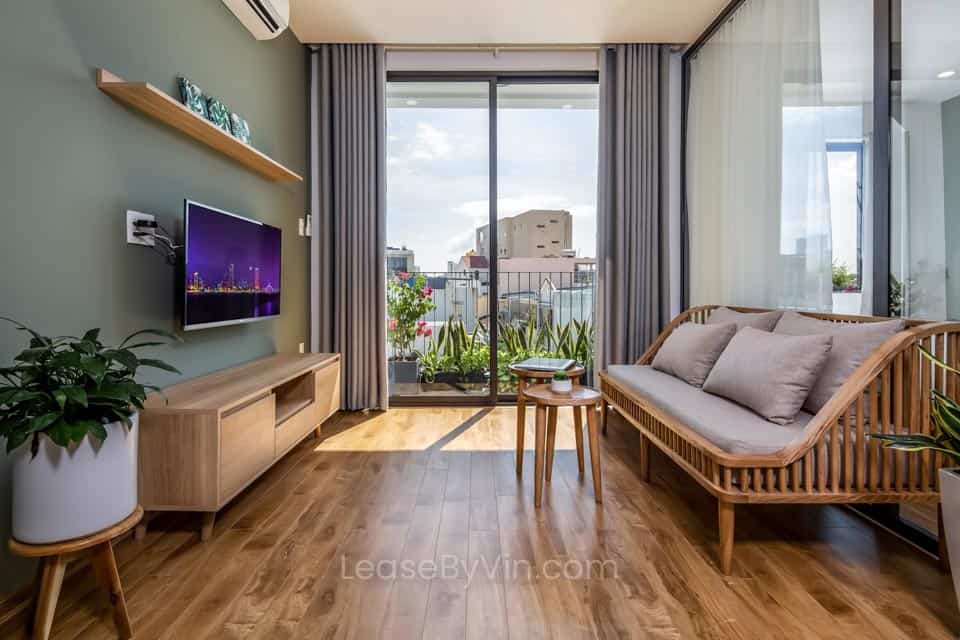 A living room with wooden floors and a large window, inspired by Hoi An city.